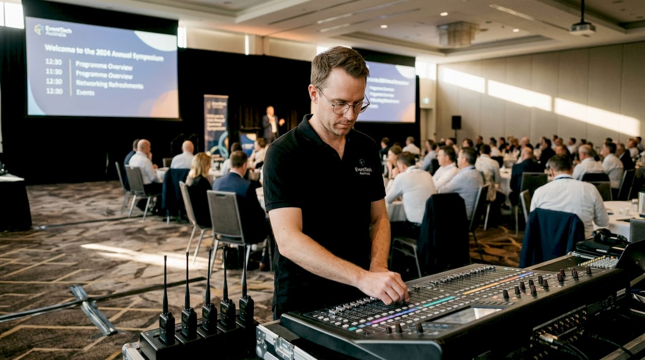 AV technician setting up mixing console at corporate event