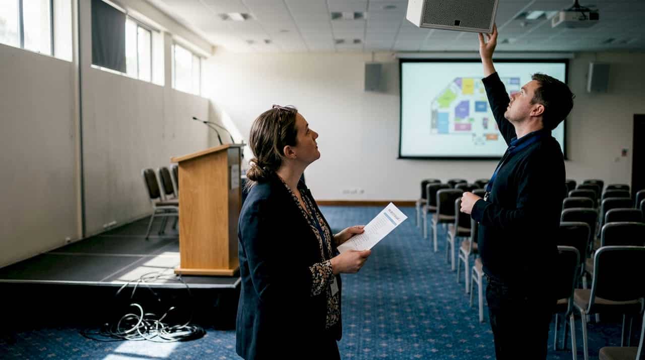 Event planner evaluates AV setup in hall